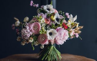 large spring bouquet full of pink ranunculus, anemones, iris, cherry blossom