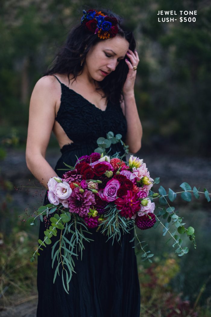 bride in black dress holding lush berry jewel tone floral bouquet during elopement