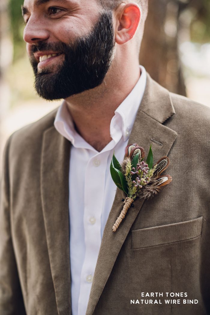 groom in taupe suit wearing an earth tone boutonnière during his elopement