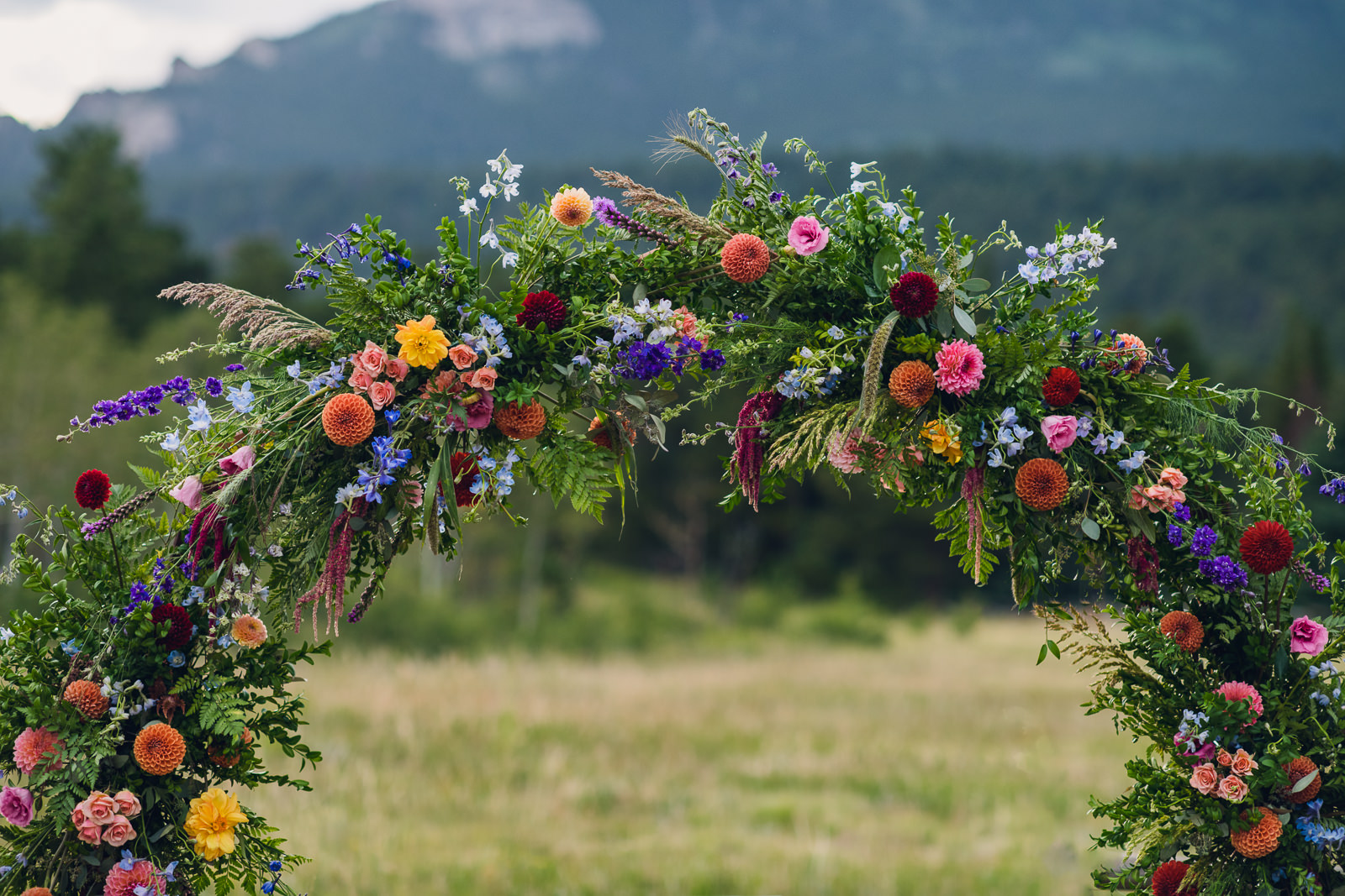 wedding circle arch covered in colorful flowers in the mountains