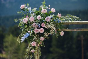 pink and blue pastel flowers on an aspen wedding ceremony arch