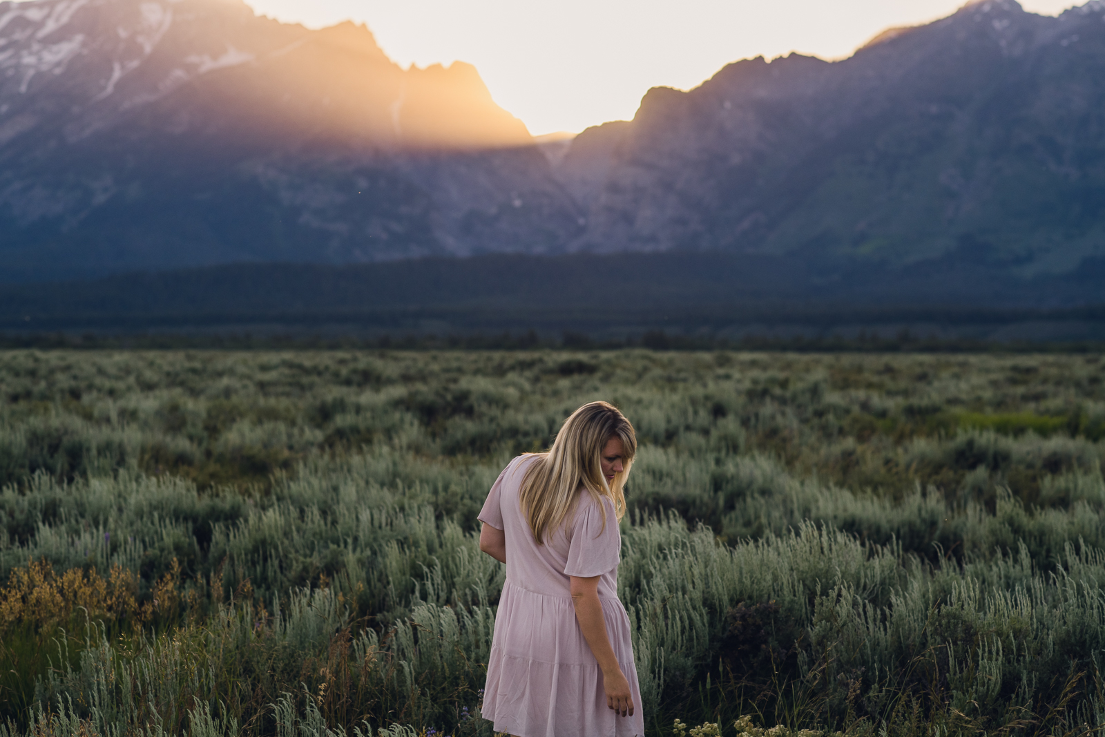 woman in front of grand teton mountain sunset