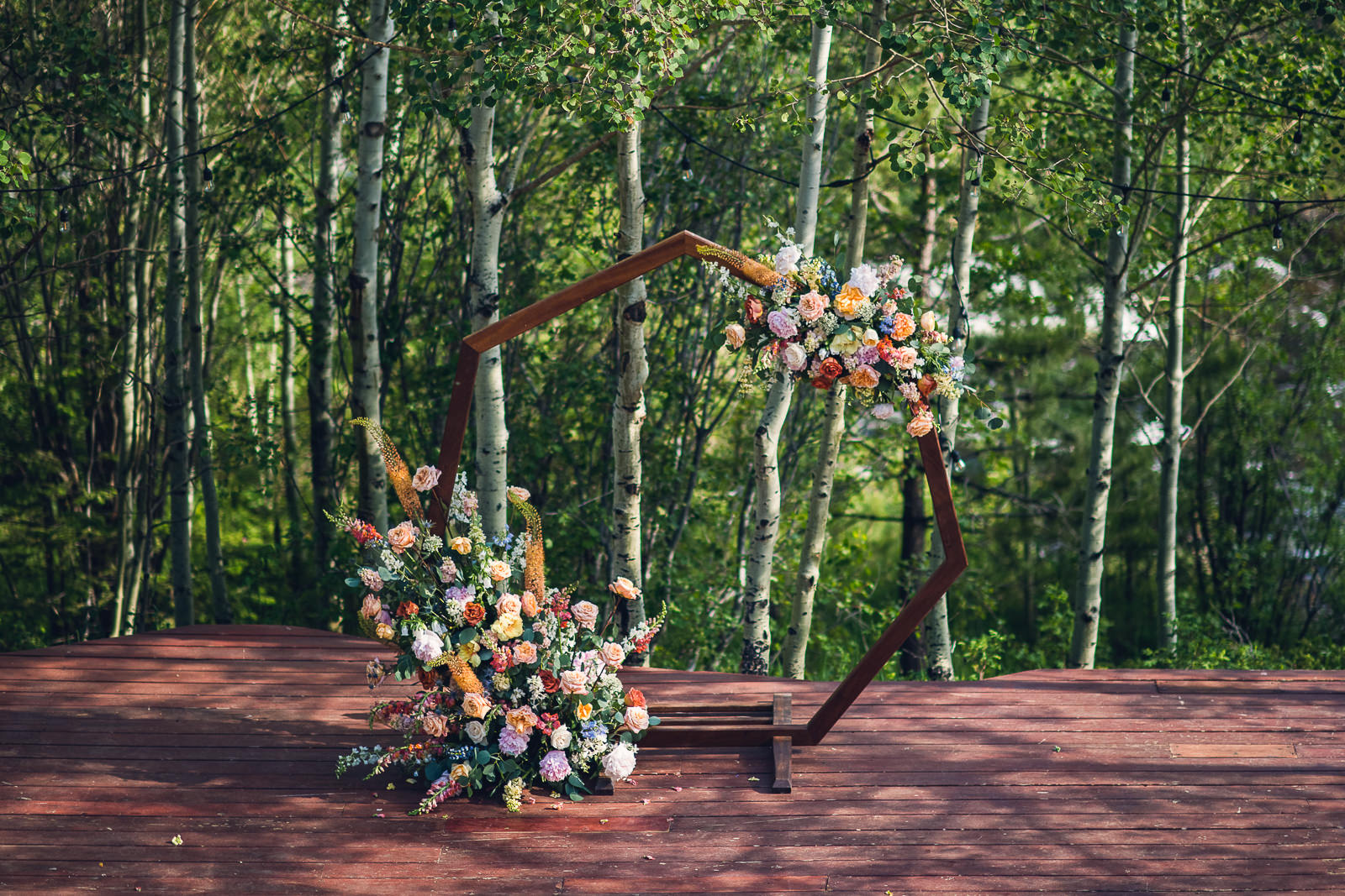 summer floral hexagon wedding arch in aspen grove