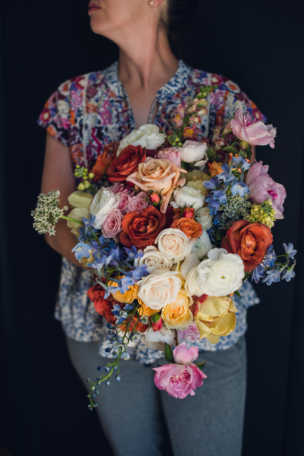 woman holding a bridal bouquet of refined colorful citrus wedding flowers