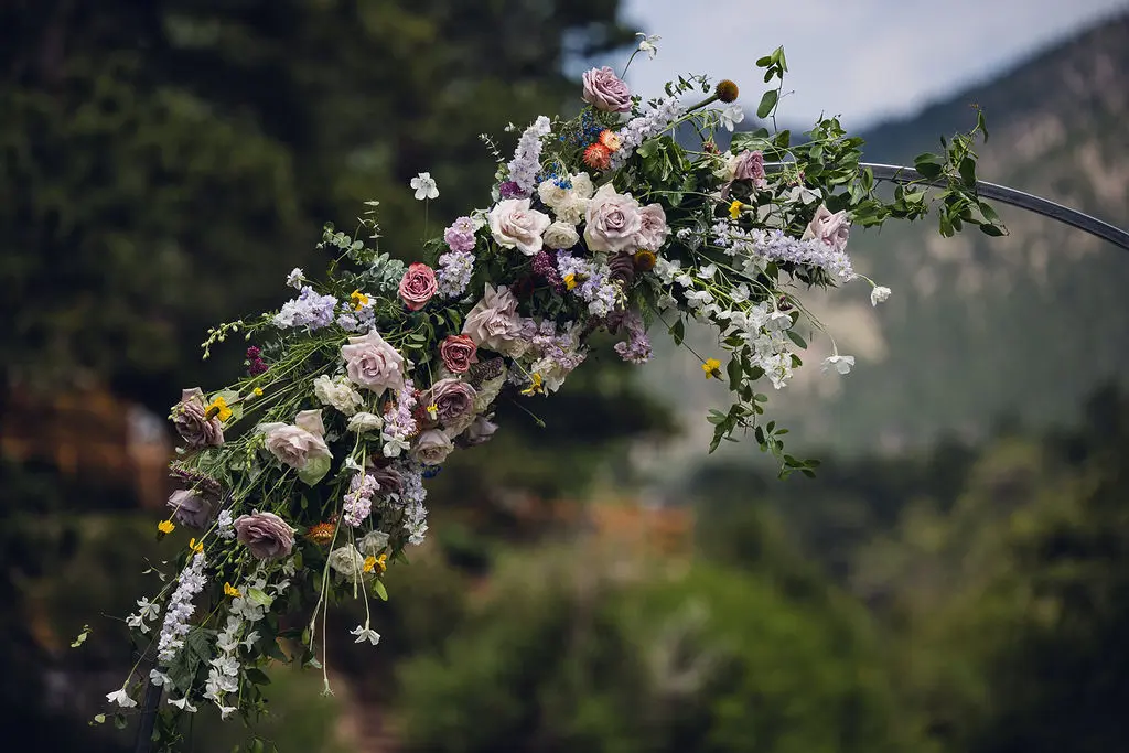 estes park wedding flowers at the landing lush pastels on a circle ceremony arch