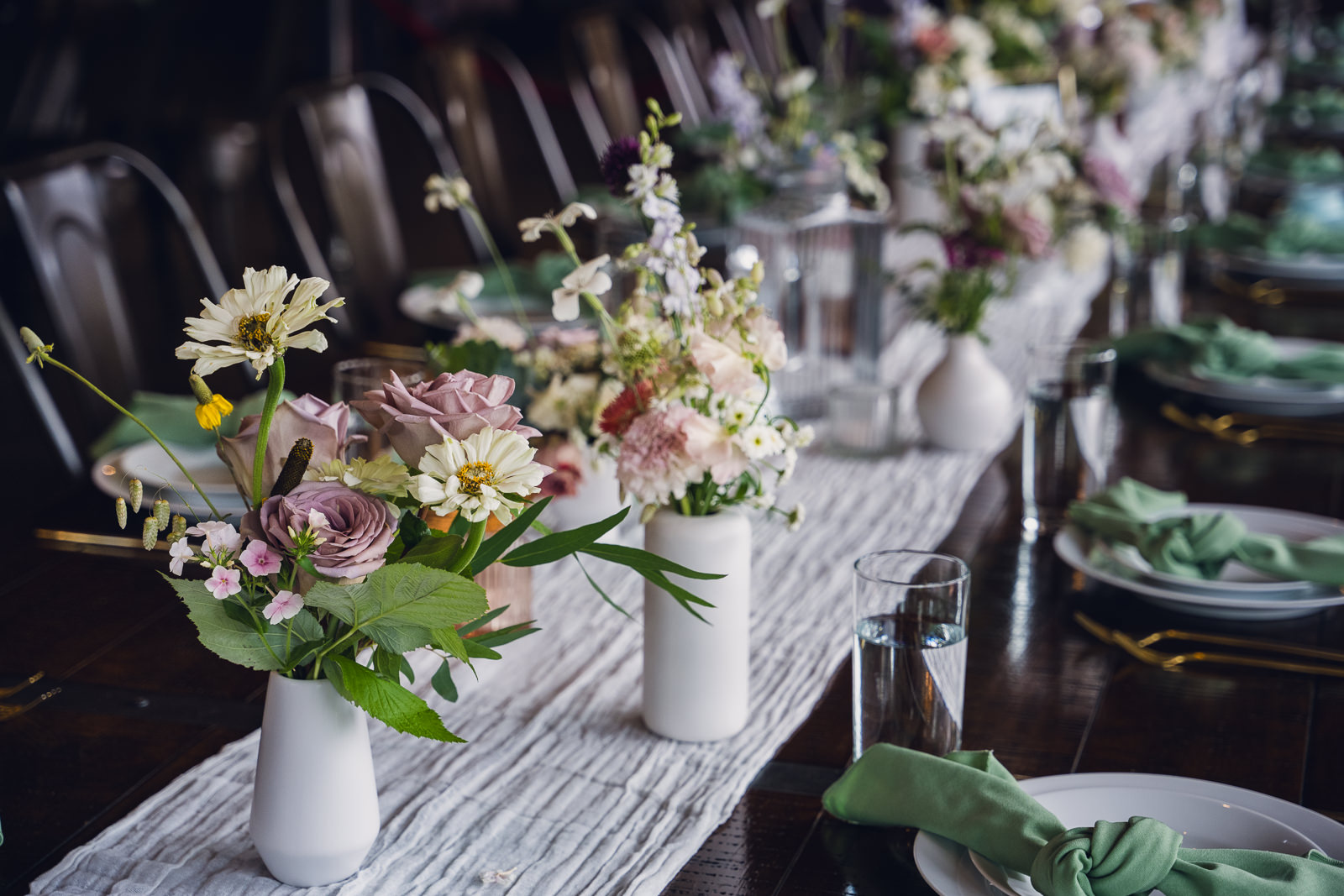 white ceramic bud vases full of flowers on a wedding reception table at the landing estes park colorado