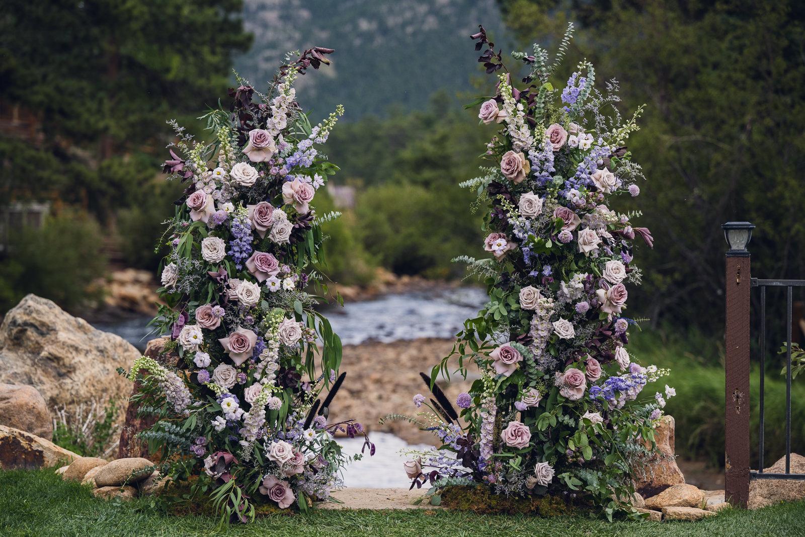 free standing floral pillars arch for wedding ceremony covered in shades of purple flowers at the landing estes park colorado