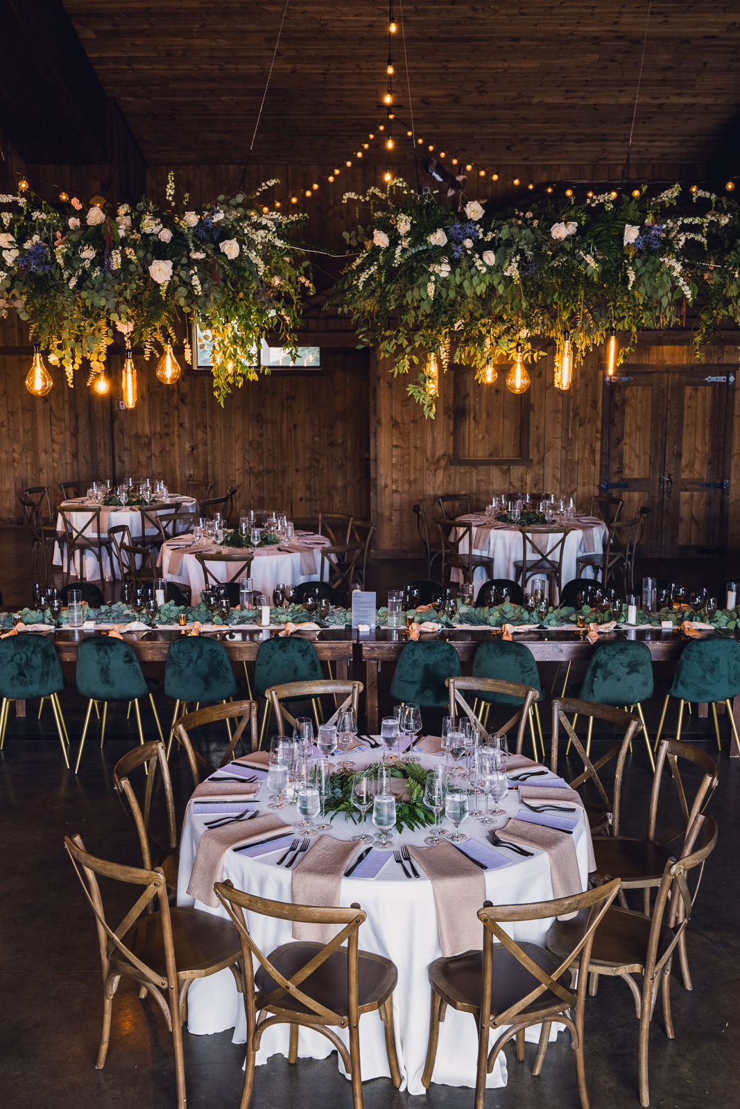 lush hanging floral installation over luxury wedding reception tables at spruce mountain colorado wedding venue